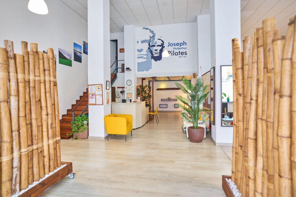 Recepción y zona de espera del estudio Equium Pilates con decoración natural y ambiente acogedor.